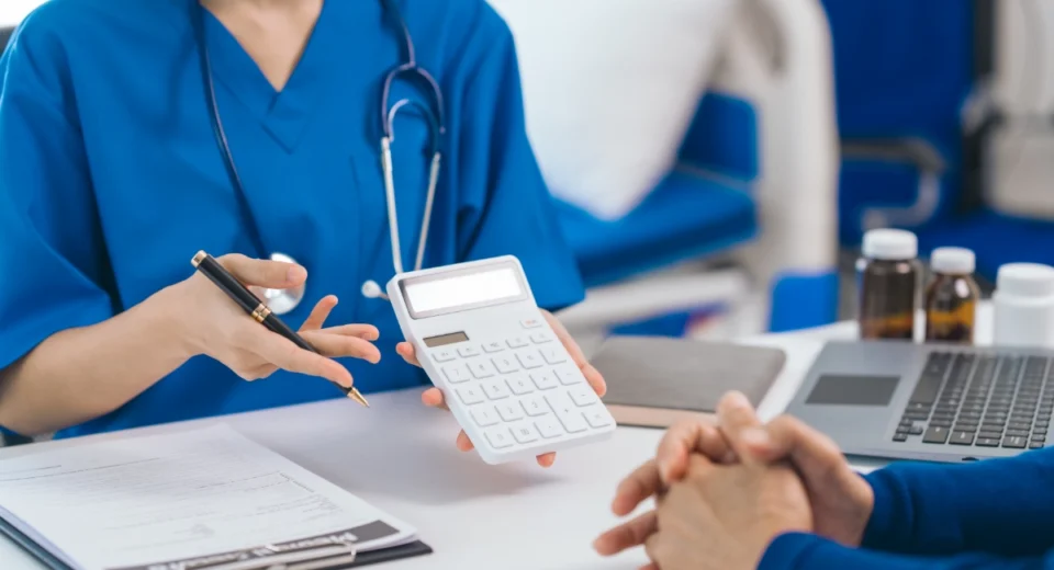 Doctor explaining Upper GI Endoscopy and Colonoscopy costs to a patient during a medical consultation.