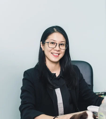 Dr. Michelle Pon Yen Kuan, a Traditional Chinese Medicine practitioner, smiling in a clinical setting.