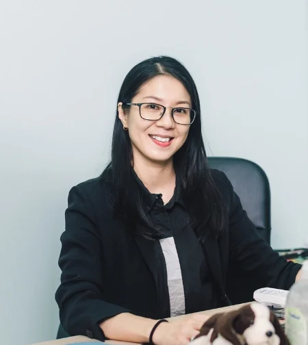Dr. Michelle Pon Yen Kuan, a Traditional Chinese Medicine practitioner, smiling in a clinical setting.