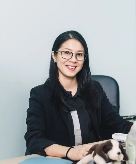 Dr. Michelle Pon Yen Kuan, a Traditional Chinese Medicine practitioner, smiling in a clinical setting.
