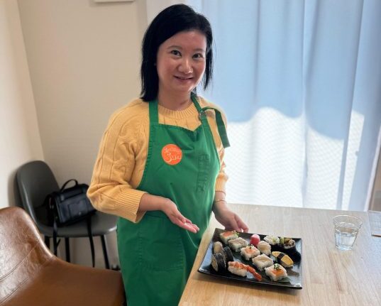 Dr. Renee Tan, Psychiatrist in Malaysia, presenting sushi at a wellness event.