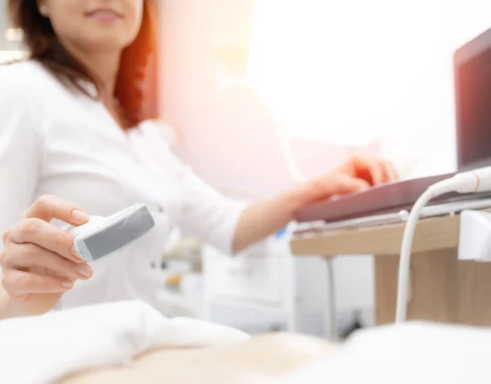 A female gynaecologist performing an ultrasound scan in a medical clinic, using advanced diagnostic imaging to assess a patient’s reproductive health.